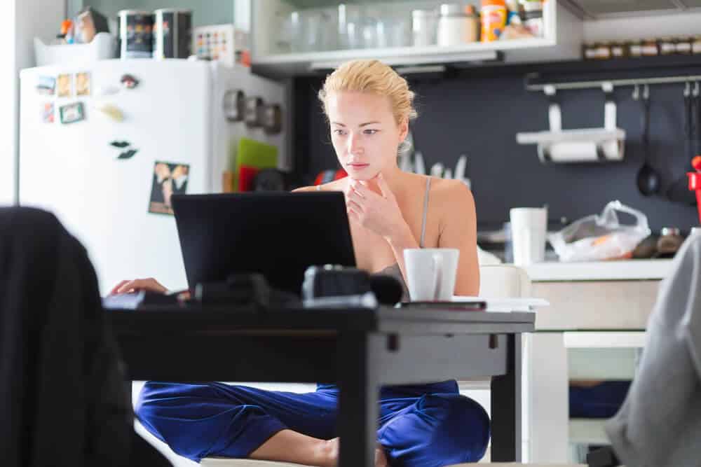 Mom at kitchen table, doing side hustle as a working mom.