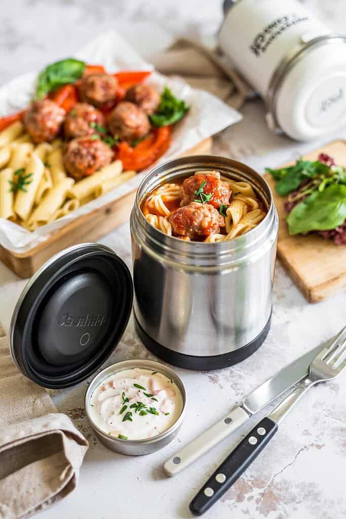 Stainless steel food container with spaghetti and meatballs ready to eat.