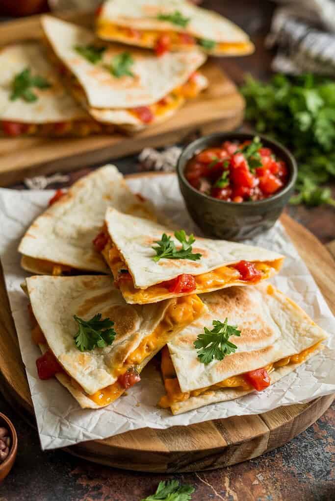 Whole grain quesadilla triangles filled with cheese and vegetables ready for a school lunch.
