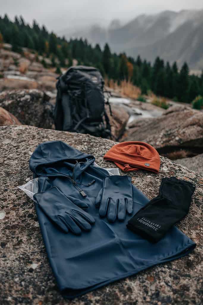 a backpack and gloves on a rock