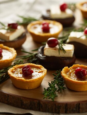 Image of thanksgiving appetizers like sweet potato, stuffed peppers, and mushrooms with chream cheese.