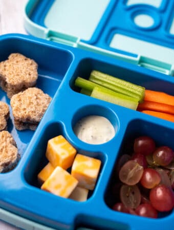 Kids bento box with sandwhich cut like stars. Cheese, fruit and veggies.